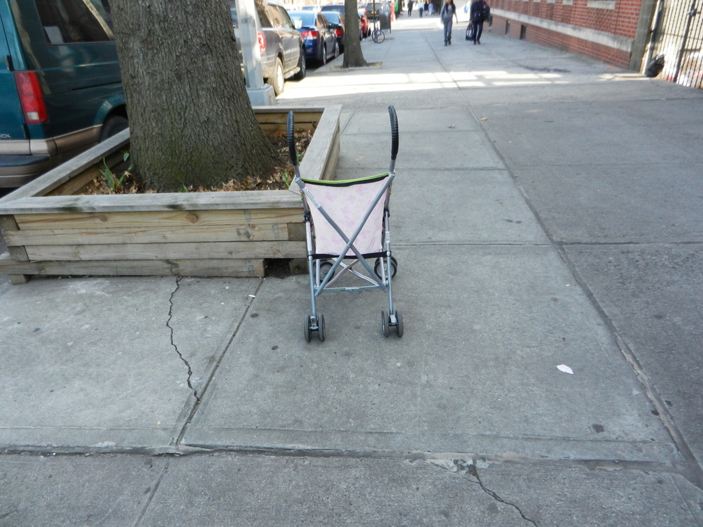 On a sidewalk, by a tree.